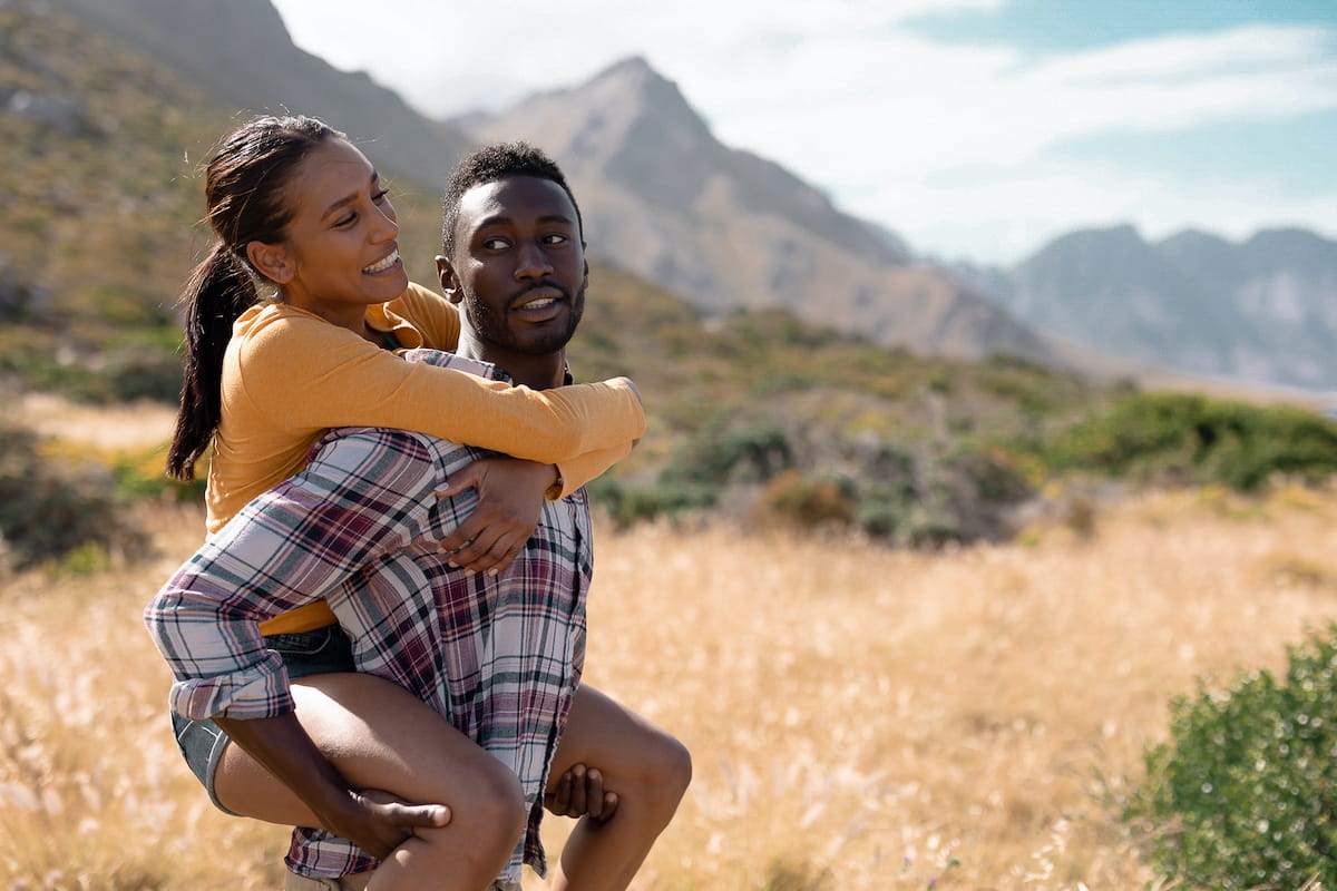 happy young couple hiking a mountain in summer