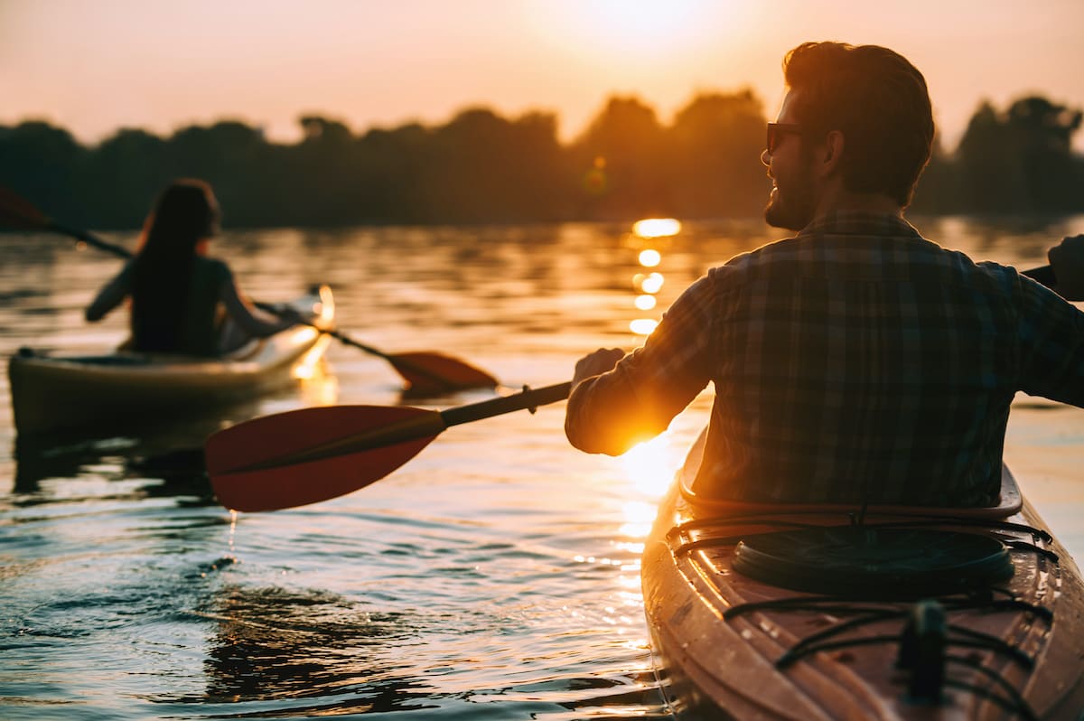 young couple kayaking at sunset