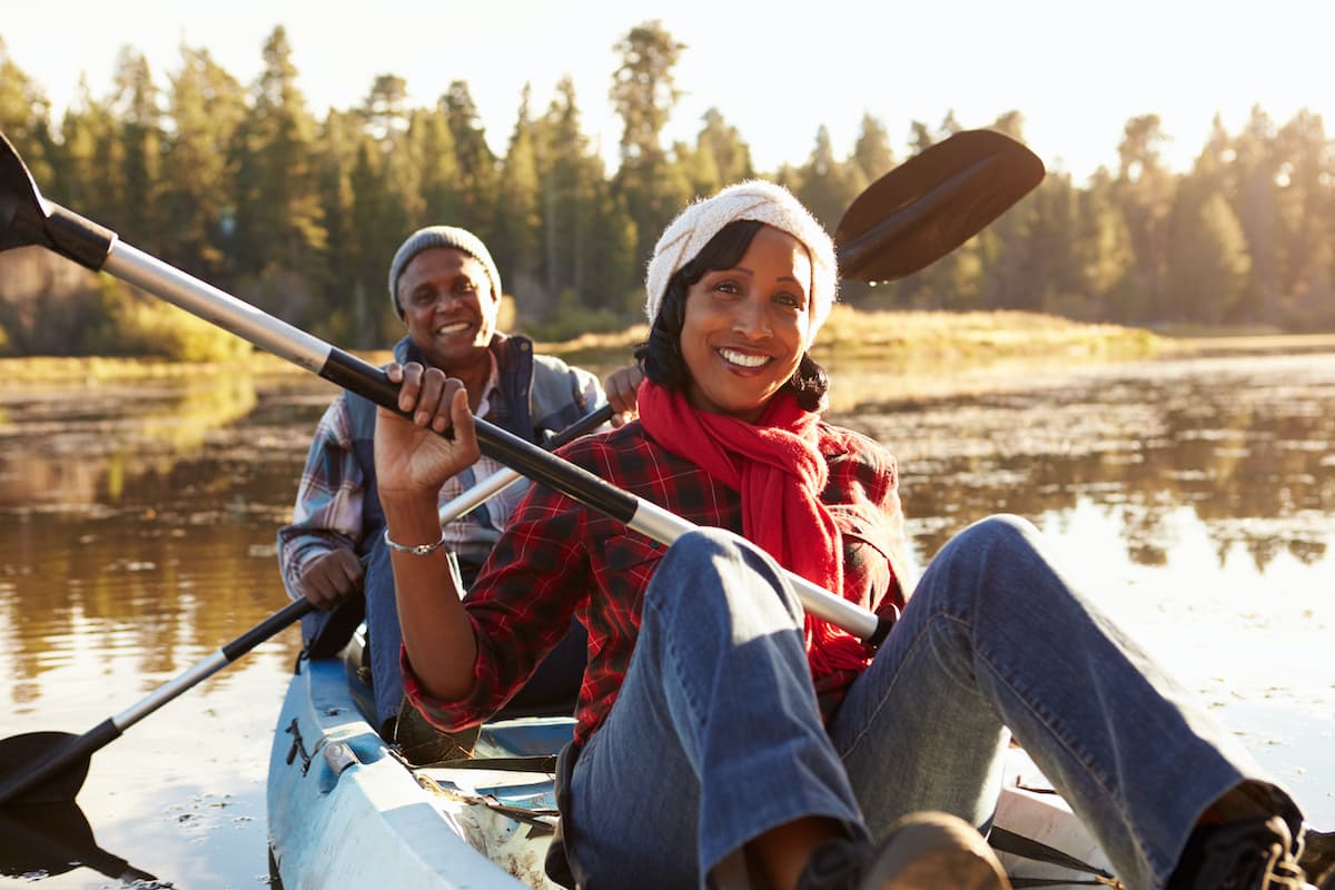 middle aged couple kayaking in autumn