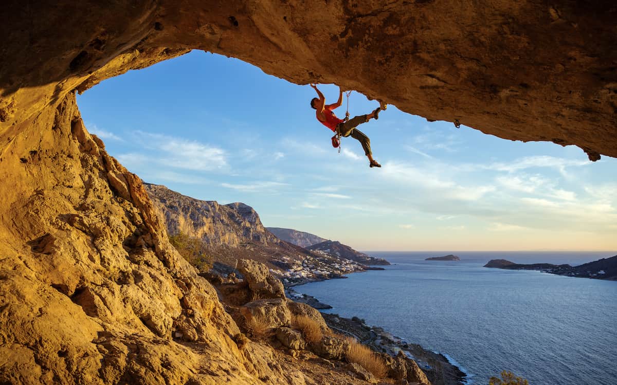 person rock climbing a dangerous rock