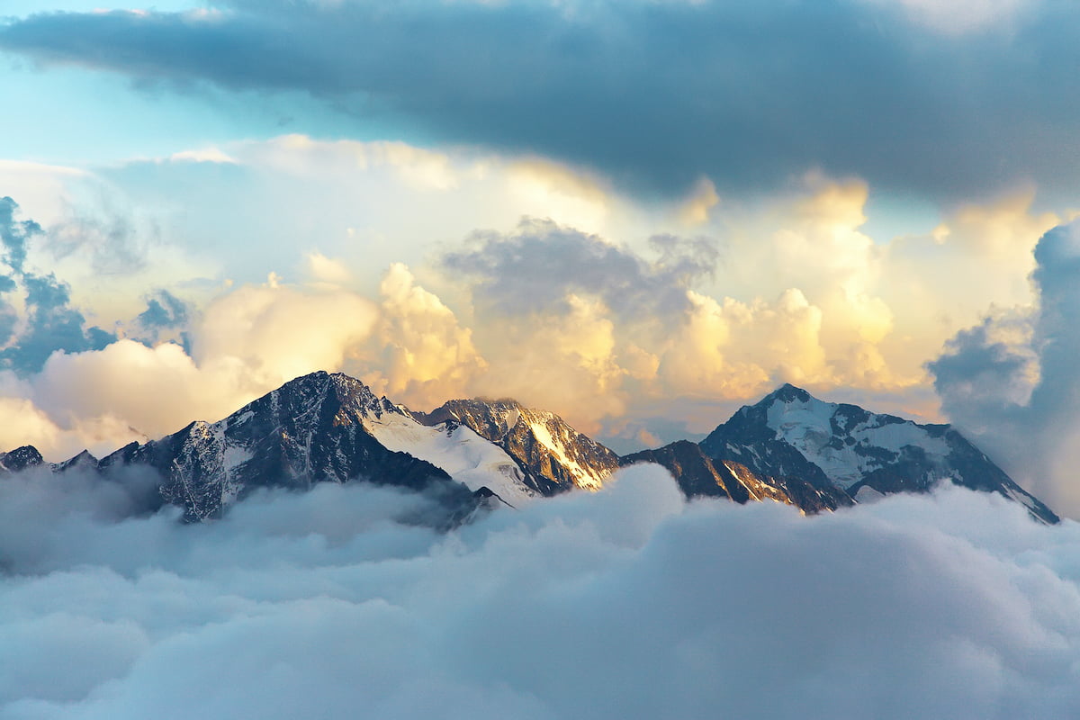 mountain top peeking through clouds