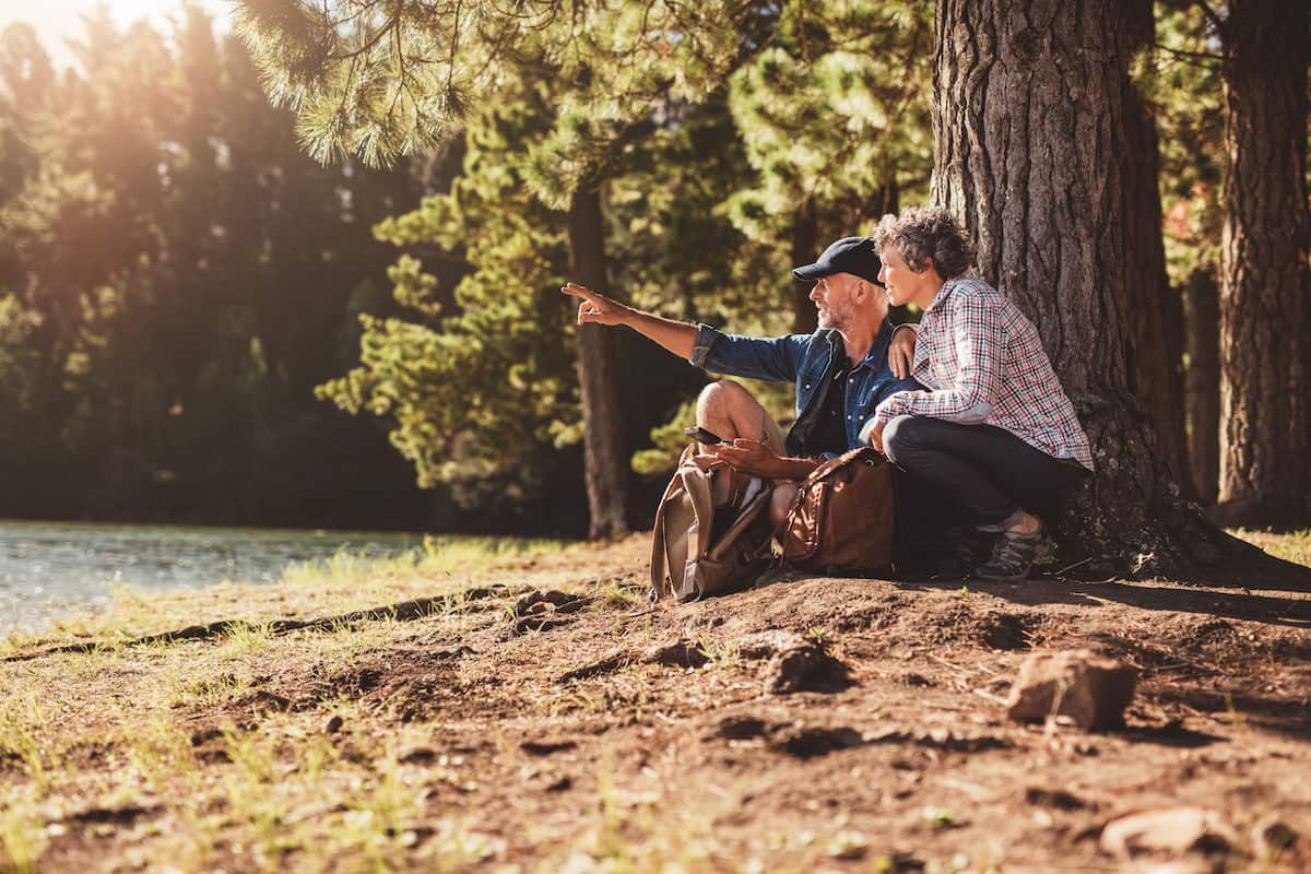 senior couple camping by a lake and looking in the distance