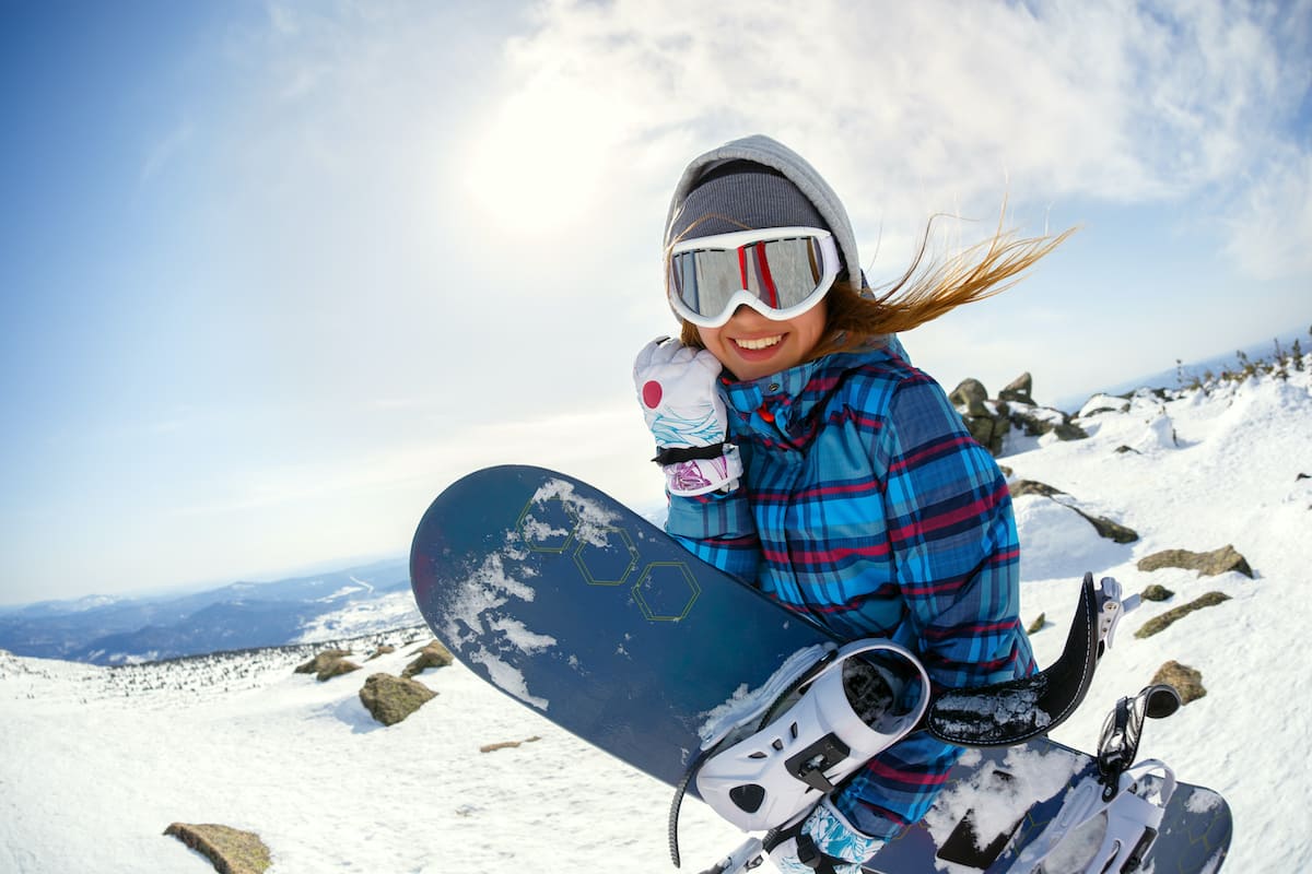 Young woman snowboarding on a snowy mountain